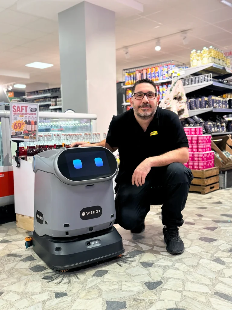 Hem 31 WeBot C40 städrobot tillsammans med personal från Matöppet mataffär